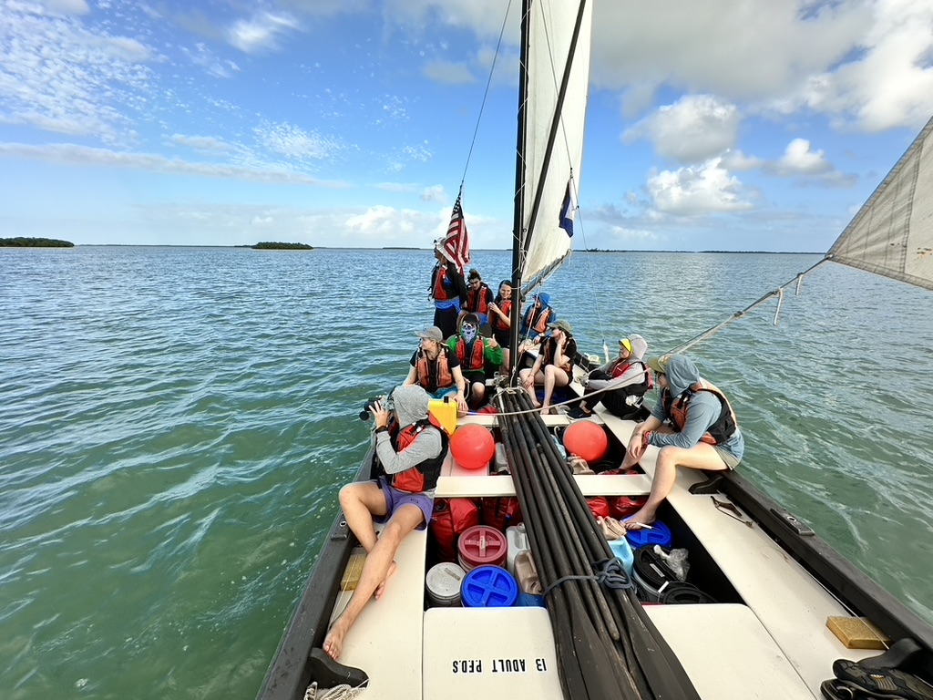 group of people on a boat with one looking through binoculars